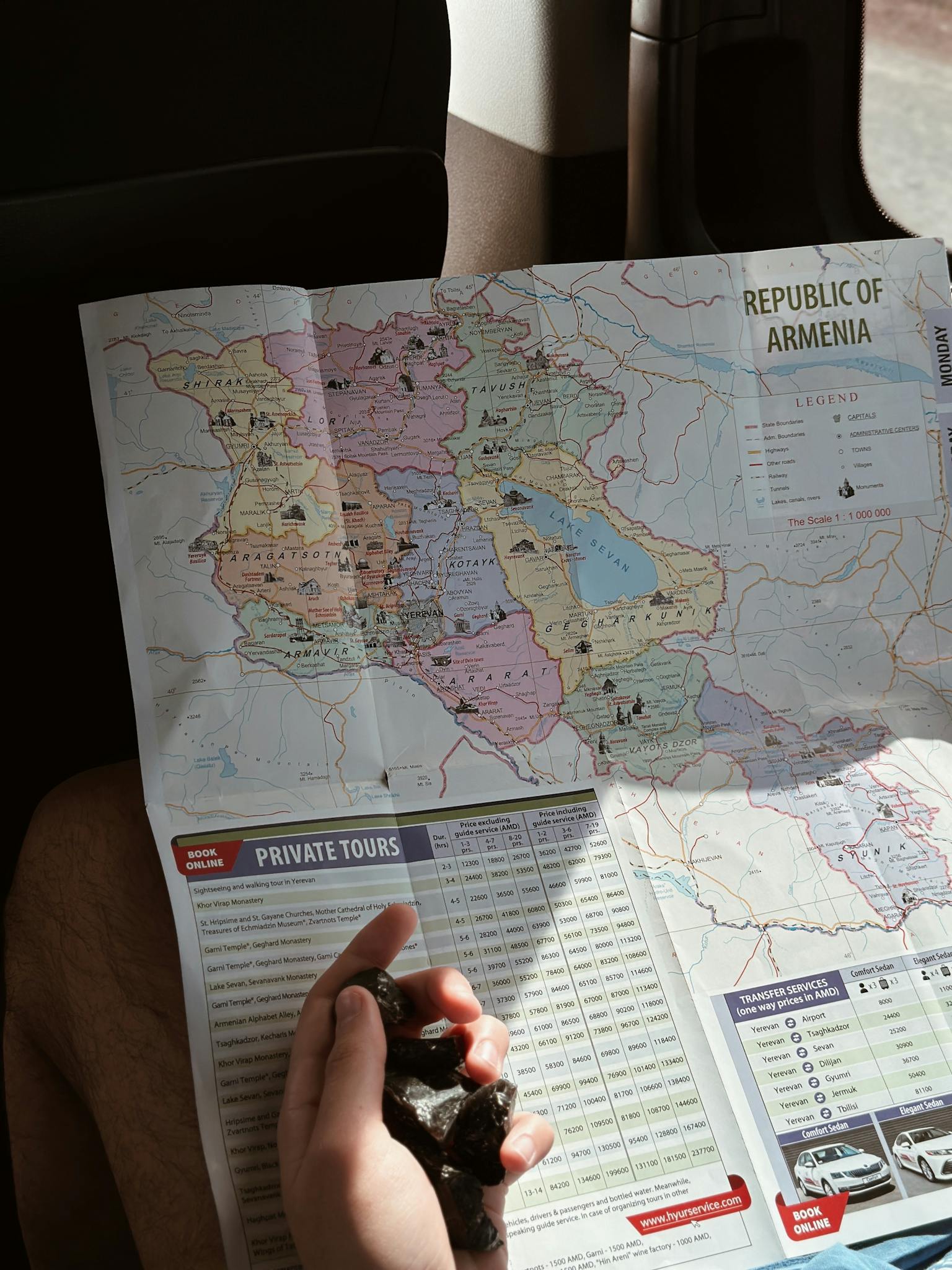 A traveler holds a detailed map of Armenia, planning their journey.